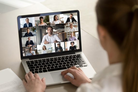 Female employee engaged in webcam conference with diverse colleagues